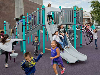 Kids playing on a PlayBooster playstructure with double slide