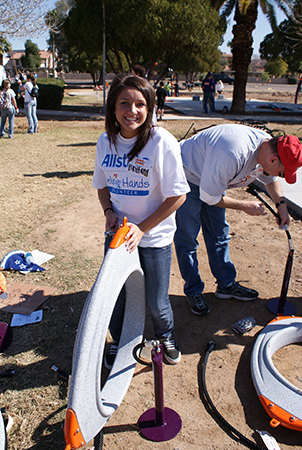 A woman holds a component for a playground at a playground installation site. 