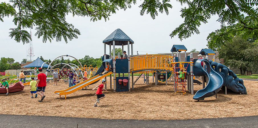 Children playing on a Evos and PlayBooster playground sets.